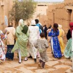 Dans les rues empierrées de Tissargate, une troupe de femmes, de dos, en caftans de fête, vont rejoindre la mariée