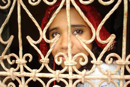 Une jeune fille de Skoura, derrière la grille d'une fenêtre