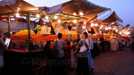 Au soleil couchant, un groupe de marocains achète des jus d'orange