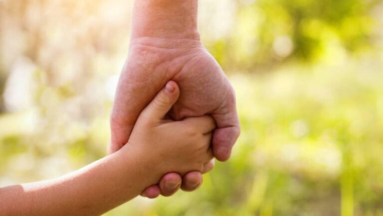 Main d'enfant dans la main d'un adulte