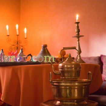 Lave main en cuivre (chellar) devant une table couverte avec des tajines