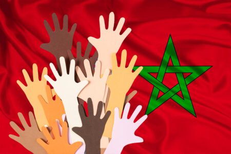 Des mains sur un drapeau marocain symbolisent la solidarité massive avec les victimes du séisme