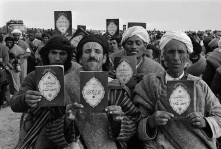 Photo en noir et blancs de Marocains avec un Coran devant eux