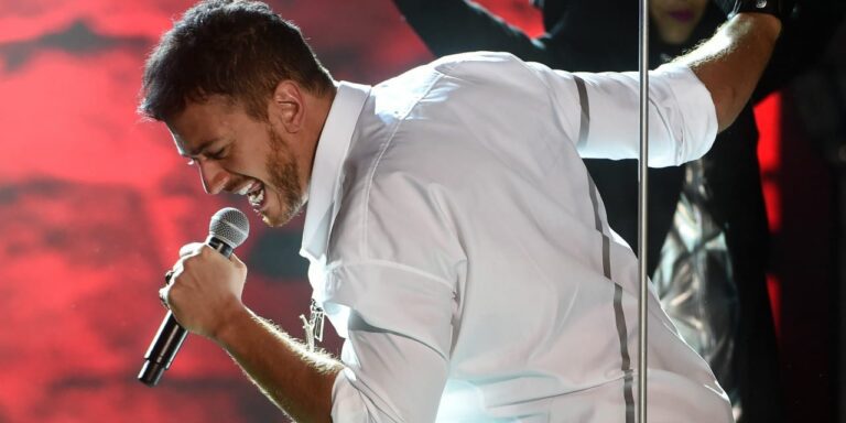 Le chanteur pop de profil, un micro à la main